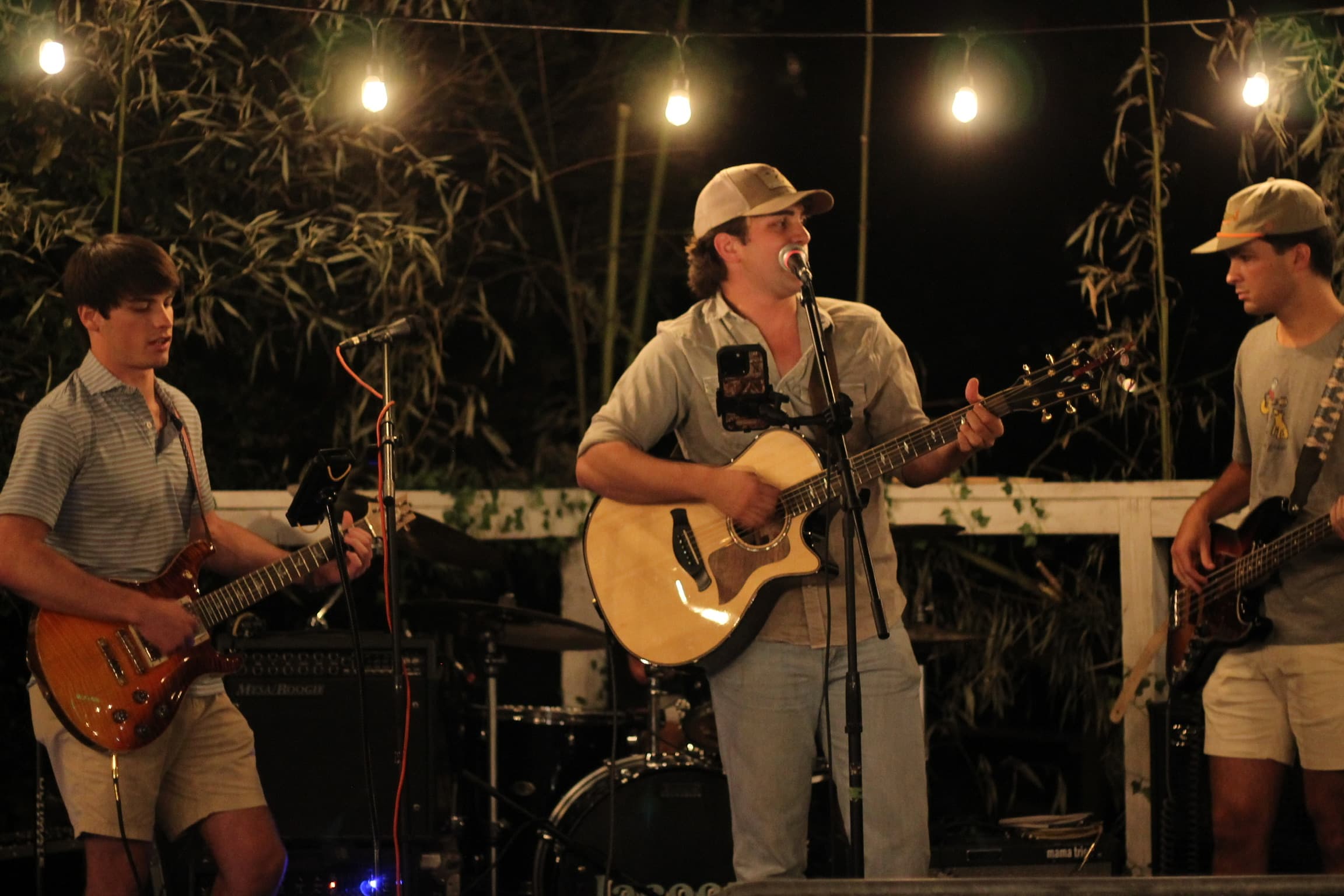 Greyhound performing an acoustic set under string lights